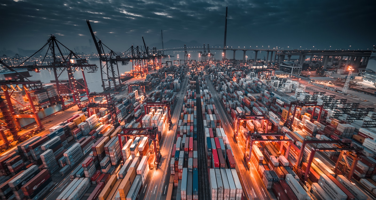 Stacked shipping containers in a Miami cargo yard at dusk