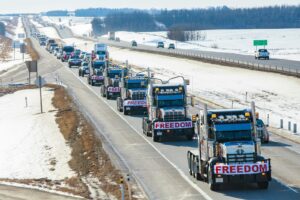 Line of freight trucks on the highway for ground shipping from the USA to Canada
