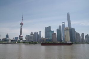 Cargo ship on the river at the Port of Shanghai with the city skyline behind