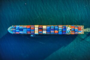 Aerial view of a fully loaded container ship crossing open blue water
