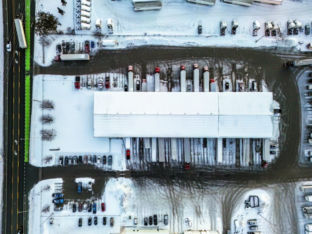 Aerial view of a cross-dock freight terminal with trailers backed into dock doors on both sides