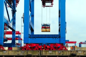 Ship-to-shore gantry crane lifting a shipping container at a seaport terminal