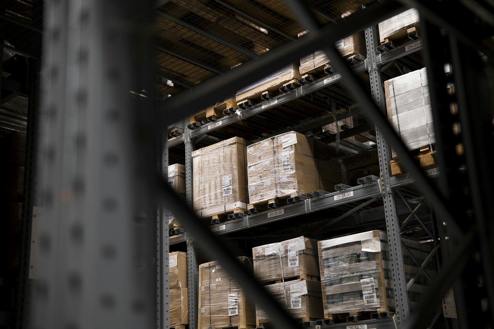 Shrink-wrapped cartons on pallets in warehouse racking, ready to ship as palletized freight