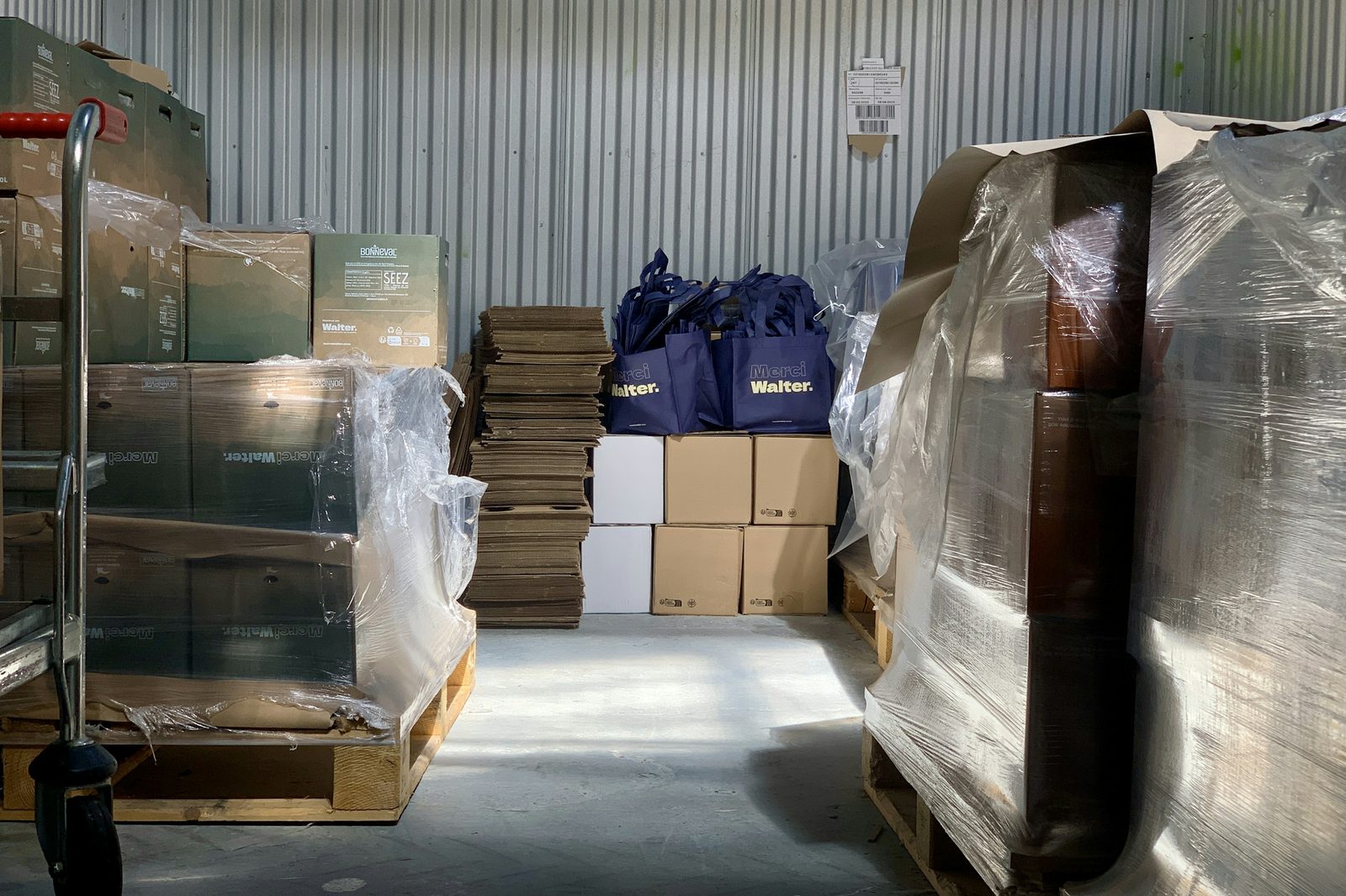 Shrink-wrapped pallets and cartons staged on a warehouse floor before pickup